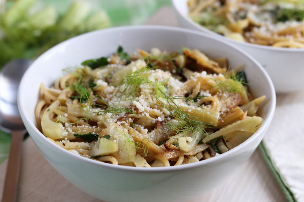 Fenchel Spaghetti in einer Schüssel, mit Parmesan und Fenchelgrün bestreut.