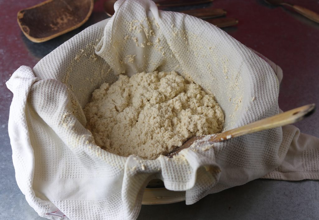 Veganer Paneerkäse wird hergestellt. Hier wird die gestockte Sojamilch abgeseiht.