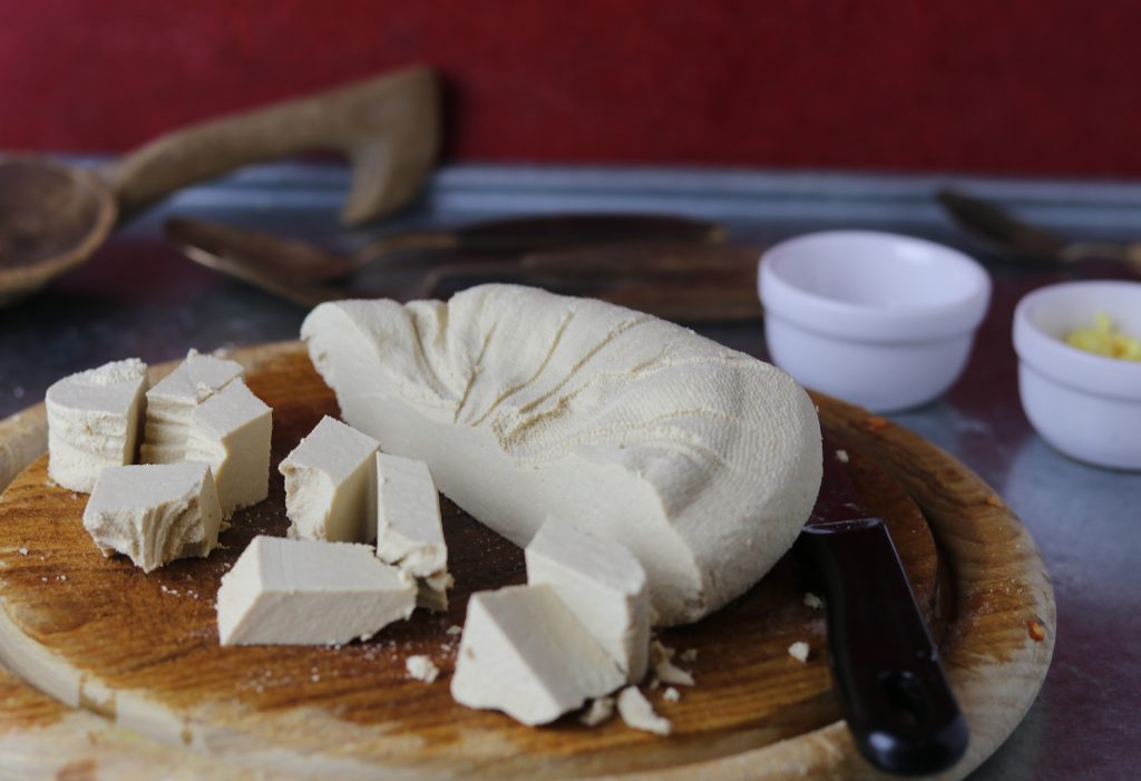 Veganer Paneerkäse wird in Würfel geschnitten.