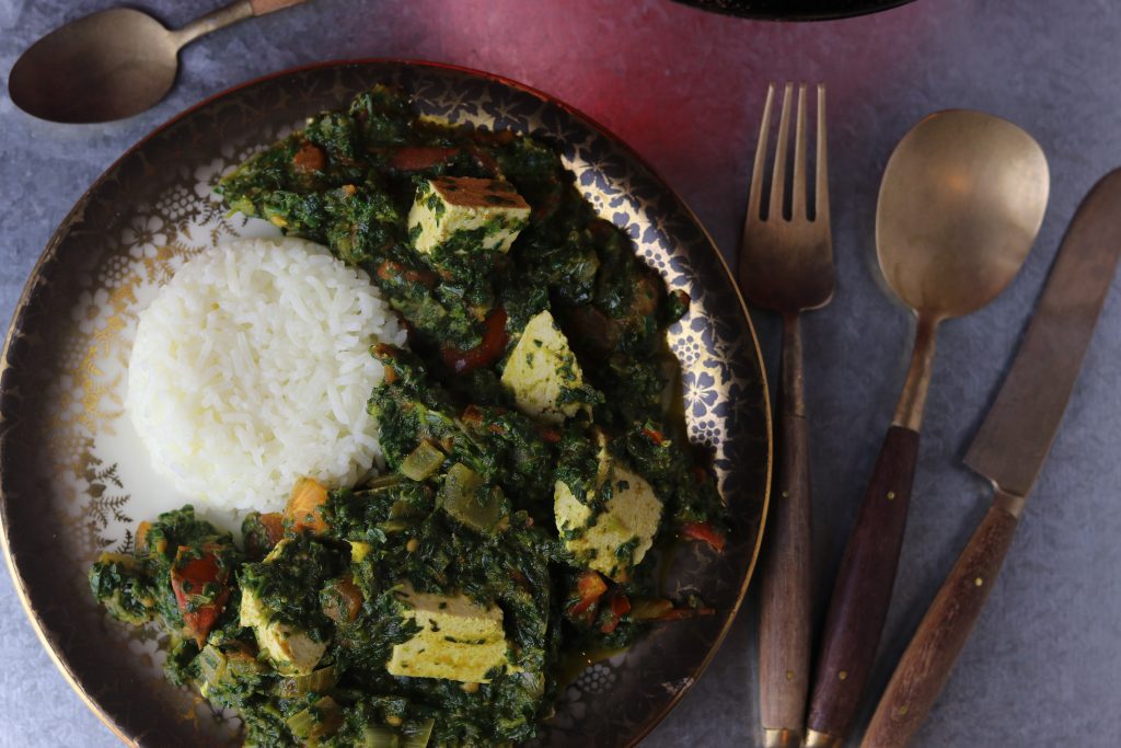 Palak Paneer, vegan, mit Reis auf einem Teller.