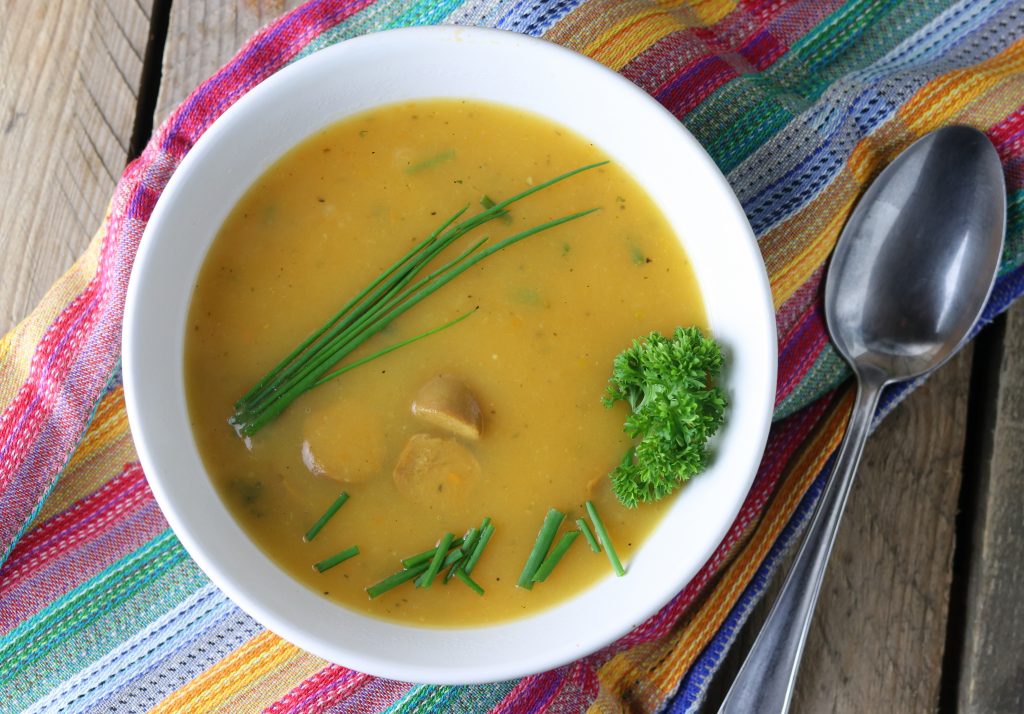 Kartoffelsuppe mit Wursteinlage, vegan, garniert mit Schnittlauch und Petersilie.