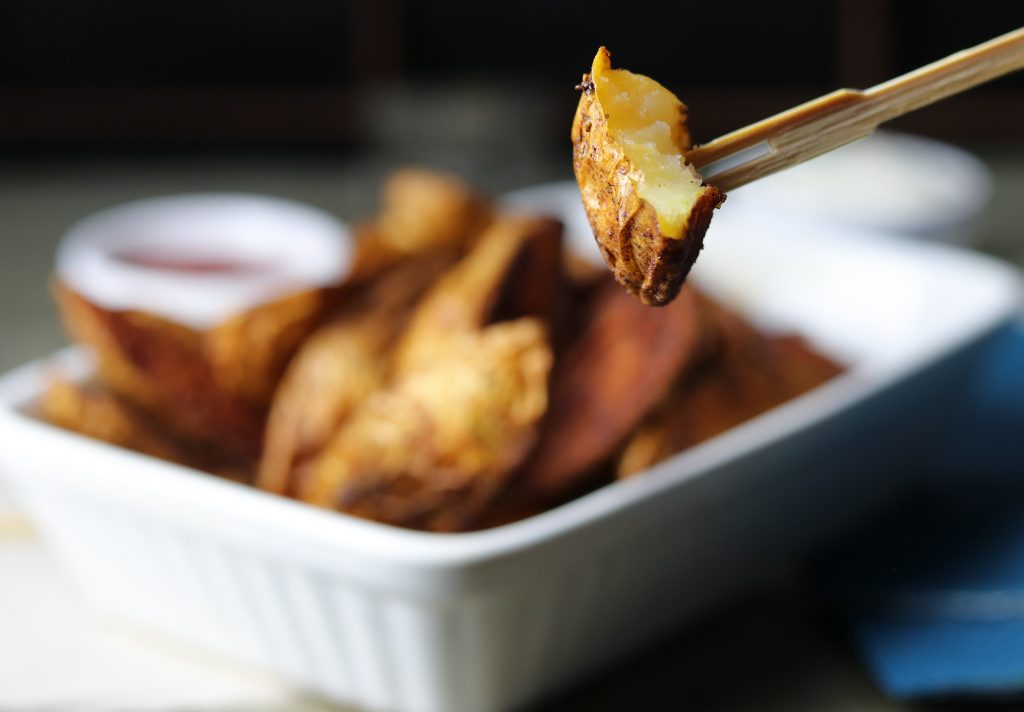 Selbstgemachte Ofenwedges, eins aufgespießt auf einem Holzspicker