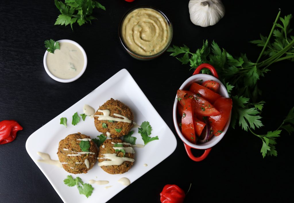 Falafel-Teller mit den besten Falafeln, Tahini-Sauce, Tomaten-Petersilien-Salat und Hummus.