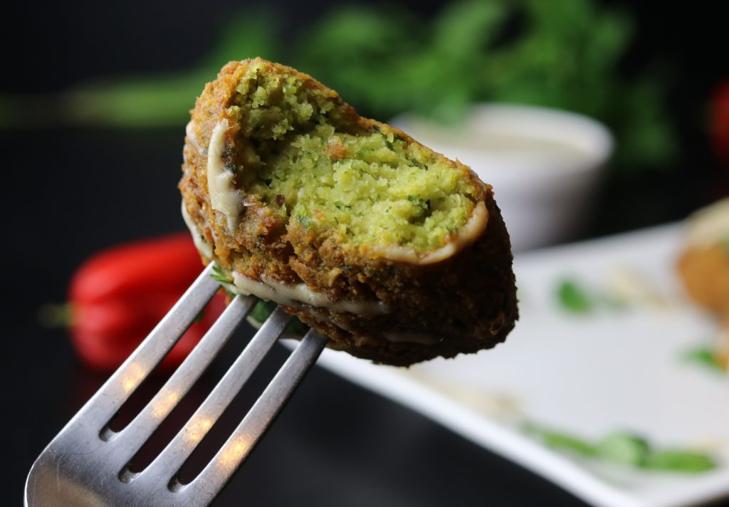 Angebissener Falafel, aufgespießt auf einer Gabel.