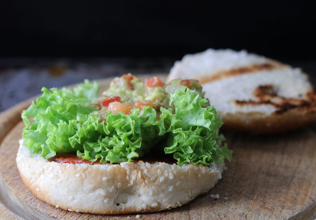 Belegen der Tex-Mex Nacho Burger: Guacamole auf Salat