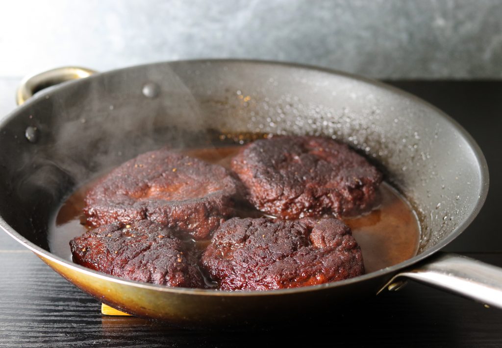 Braten der veganen Steaks in der Rotweinglasur