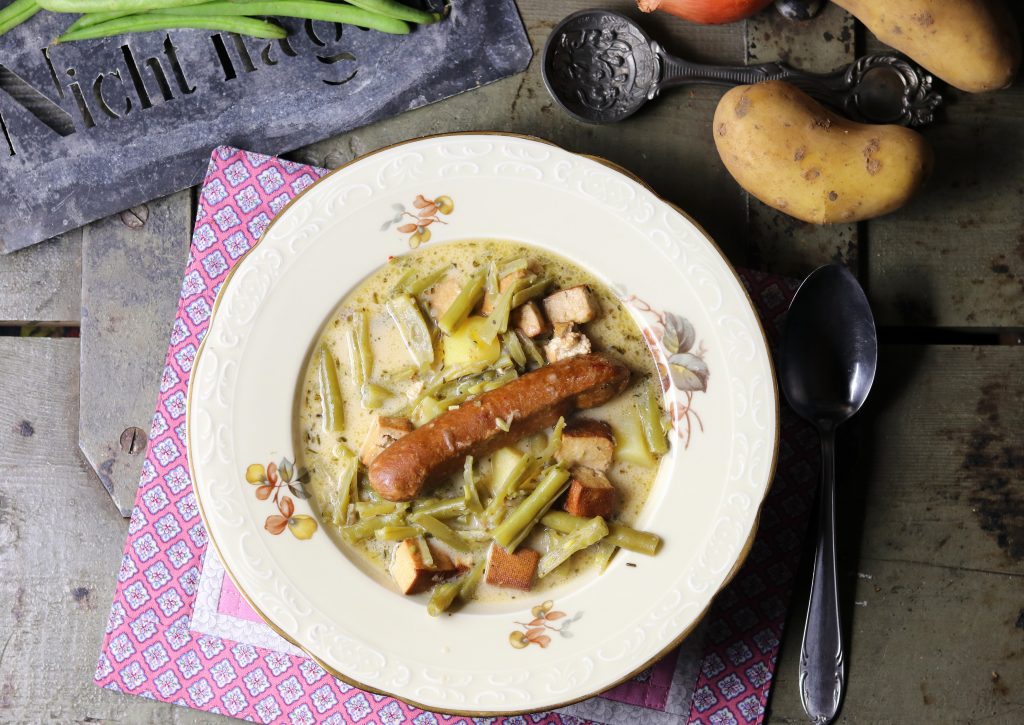Schnippelbohnensuppe - grüne Bohnensuppe in einem antiken Suppenteller.