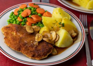 Schnitzel, Kartoffeln, Sauce, Erbsen, Möhren