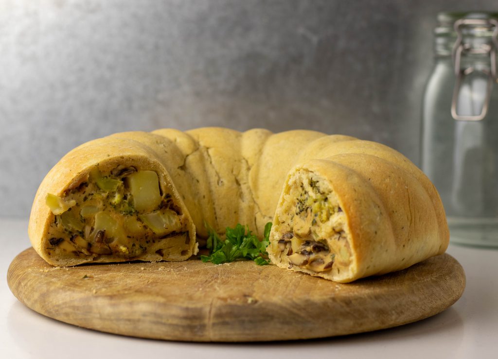 Angeschnittener Pot Pie auf einem Holzbrett.