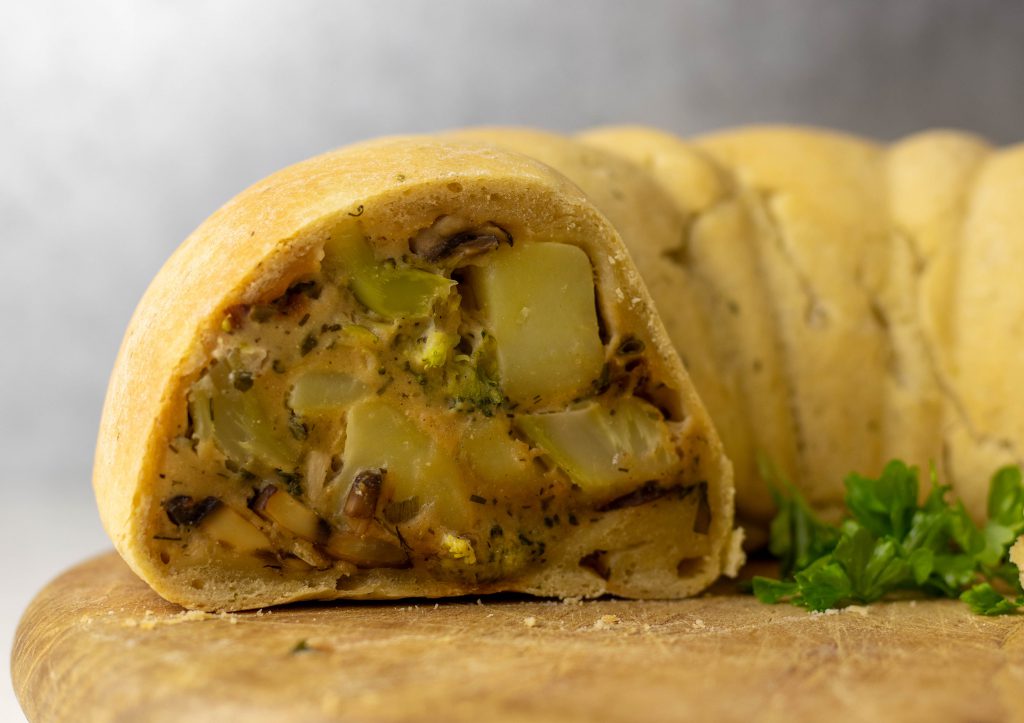 Veganer Pot Pie im Anschnitt Gefüllt mit frischem Brokkoli und Pilzen in feiner, würziger, leicht käsig schmeckender Creme