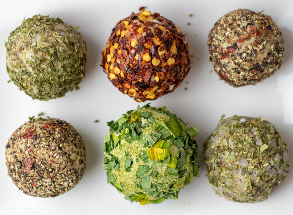 Ein köstlicher, veganer Frischkäse, gerollt in schmackhaften, aromatischen Kräutern und Gewürzen.