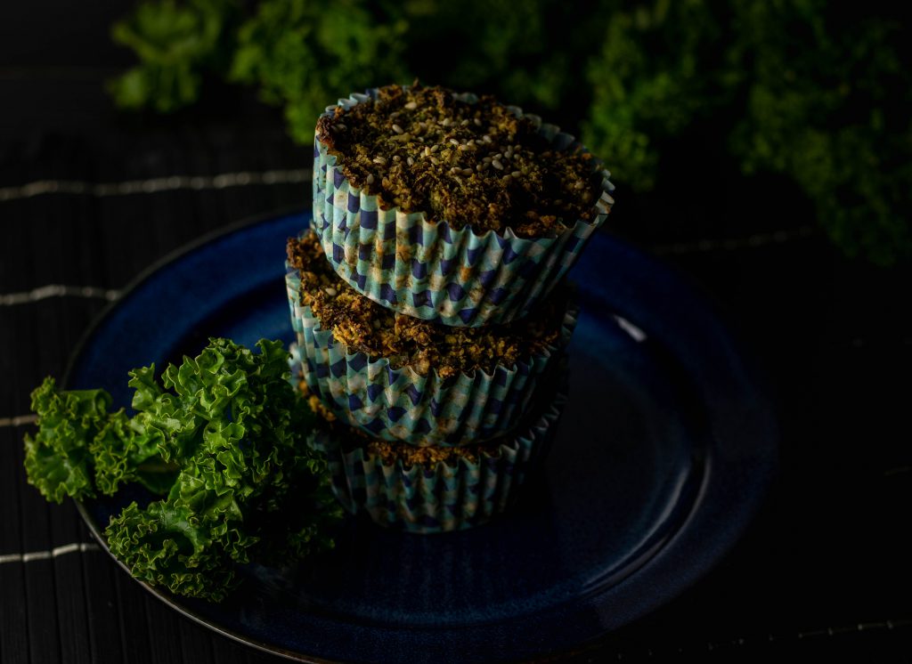 Grünkohl-Cupcakes au einem Teller, darum frischer Grünkohl.