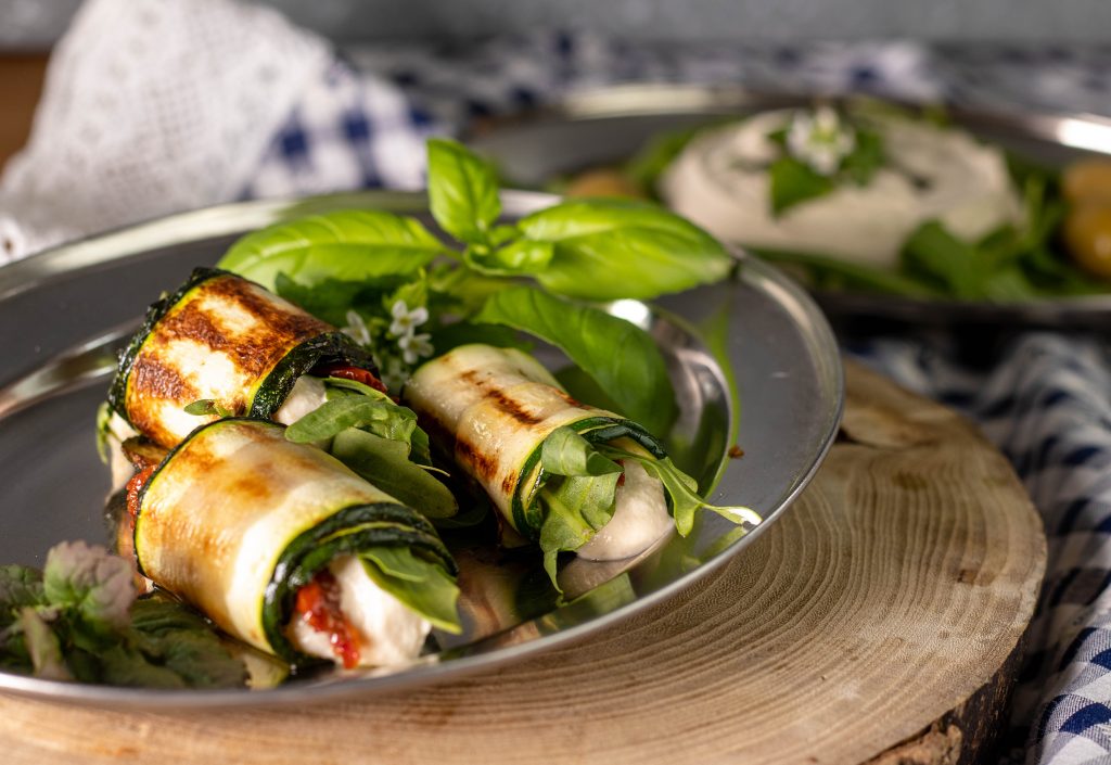 Mit Rucola und getrockneten Tomaten eingerollt