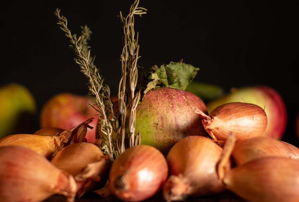 Frische Septemberernte aus Schalotten, Äpfeln und Kräutern