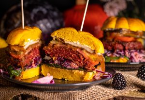 A meaty patty with cole slaw in a pumpkin bun