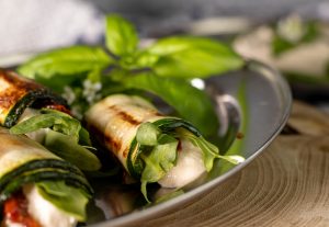 Vegan ricotta with sun-dried tomatoes and rocket rolled up in grilled zucchini