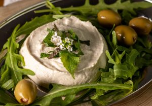 With rockets, olives, herbs and edible flowers