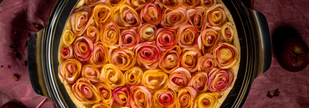 Feinster Mürbeteig trifft auf eine Cremeschicht und zarte Herbstrosen aus Äpfeln