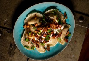 Vegane Piroggen mit veganer Sour Cream, gebratenen Zwiebeln und veganem Schinken