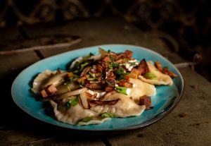 Vegane Piroggen mit veganer Sour Cream, gebratenen Zwiebeln und veganem Schinken