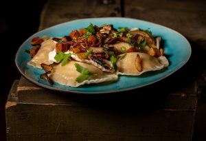 Vegane Piroggen mit veganer Sour Cream, gebratenen Zwiebeln und veganem Schinken