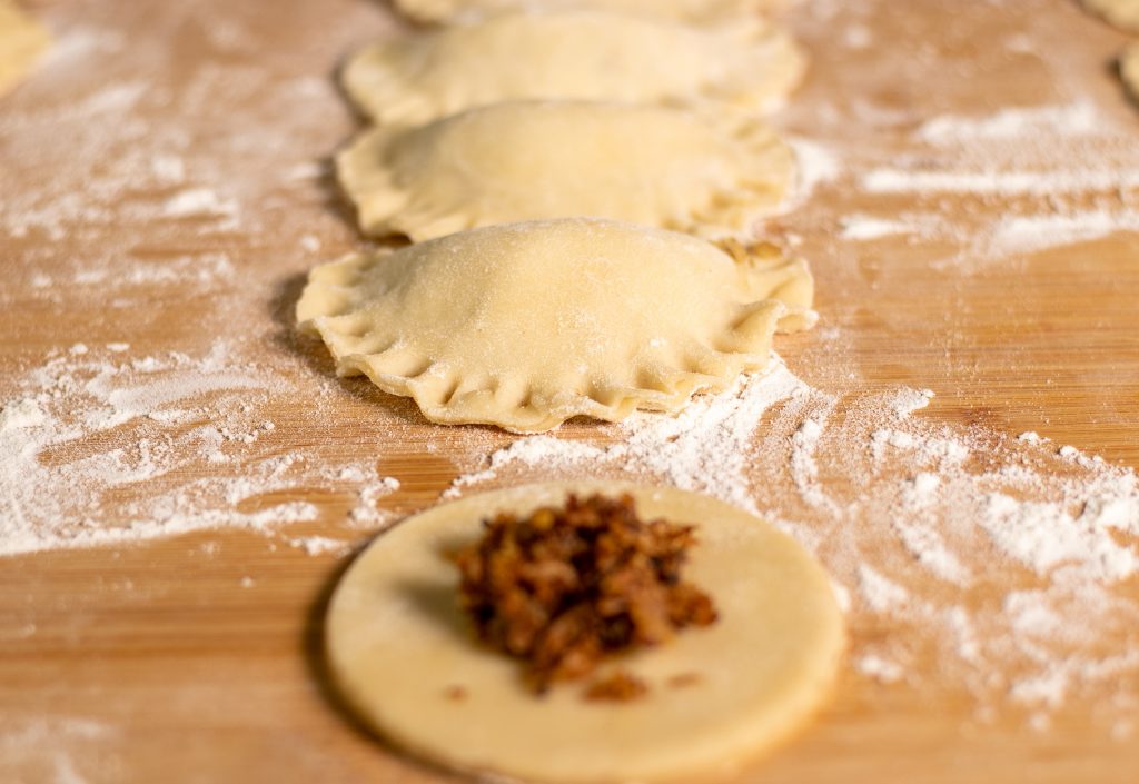 Rohe vegane Piroggen auf einer Arbeitsplatte.