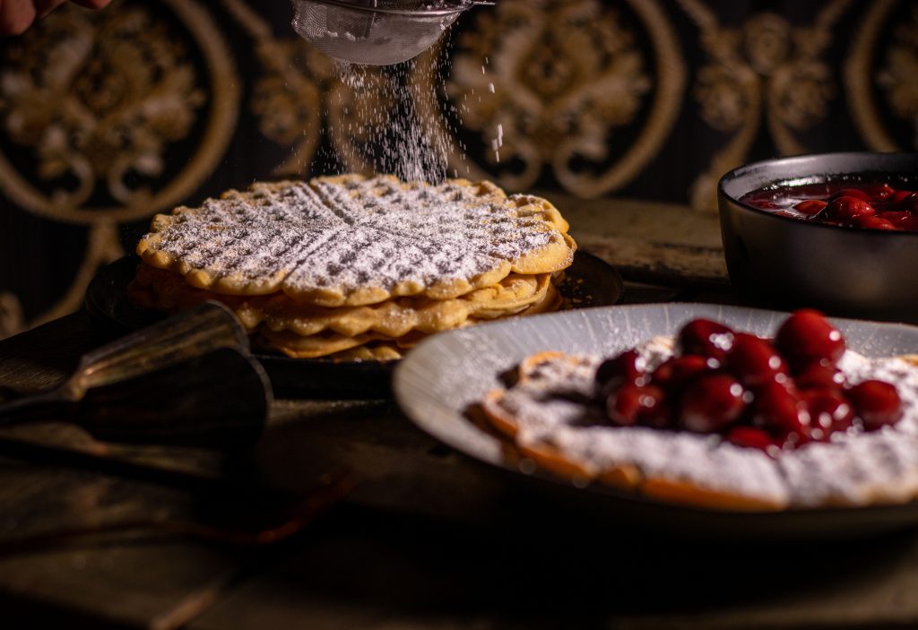 Waffeln mit heißen Kirschen und Puderzucker