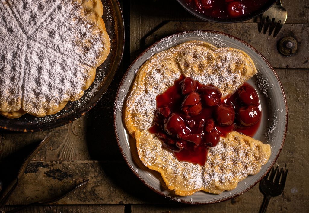 Vegane Waffeln mit Puderzucker und Kirschen