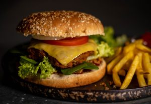 Veganer Cheeseburger mit Pommes und Salat