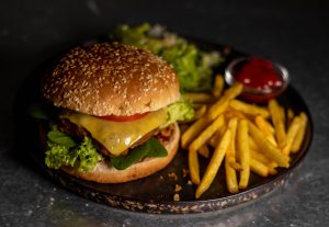 Veganer Cheeseburger mit Pommes und Salat