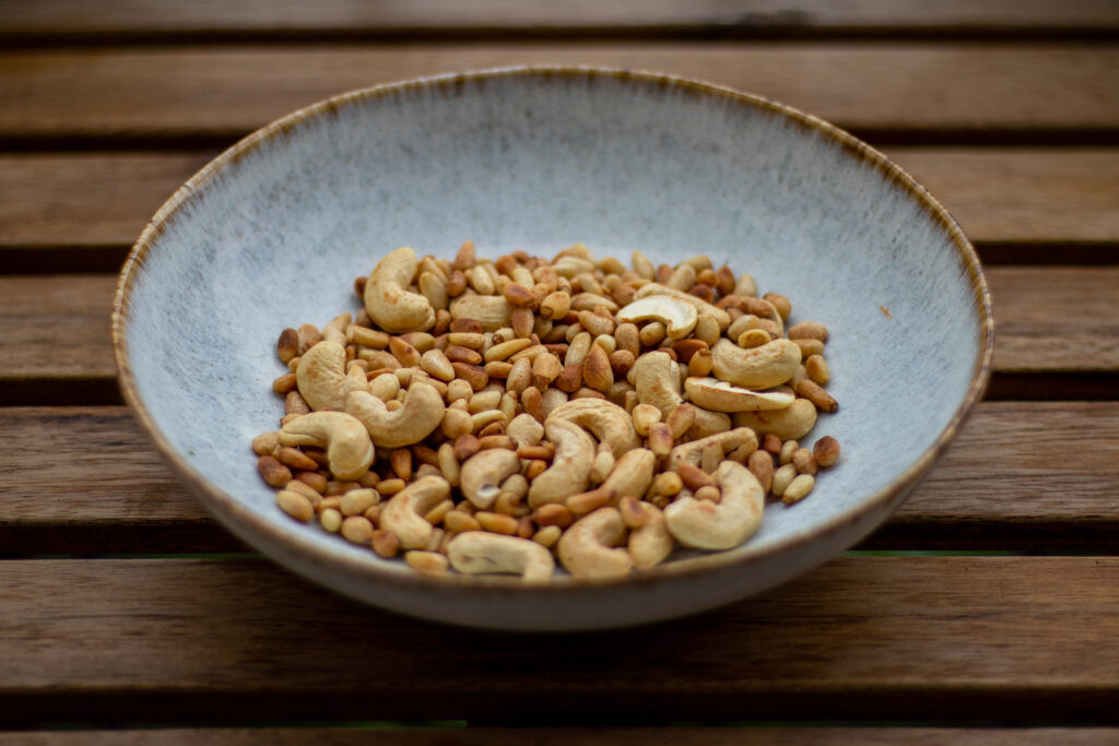 Geröstete Pinienkerne und Cashews auf einem Teller