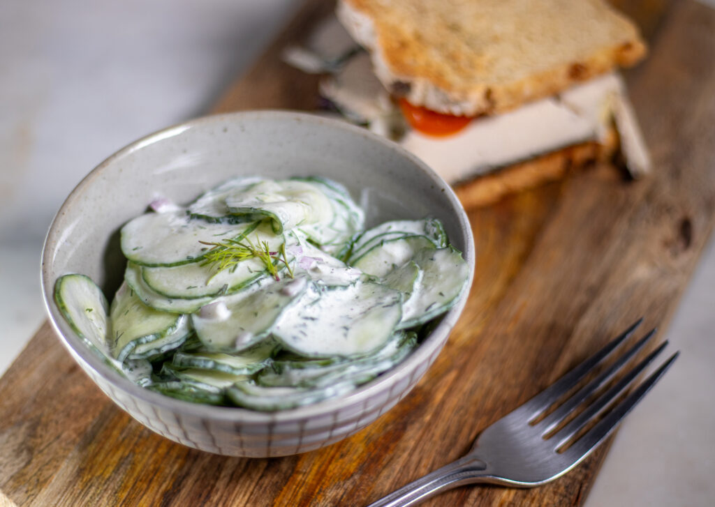 Salat nach Daily Vegan in Schale mit Brot auf Holzbrett