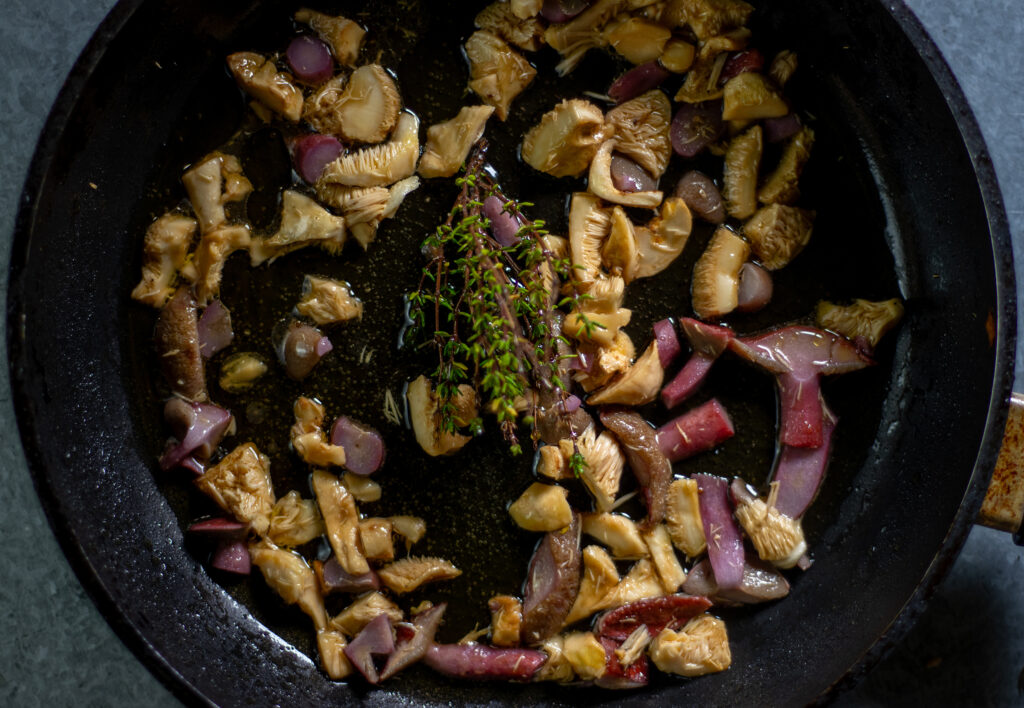 Kuhröhrlinge verfärben sich beim Braten violett. Hier in einer Pfanne mit Semmelstoppelpilzen