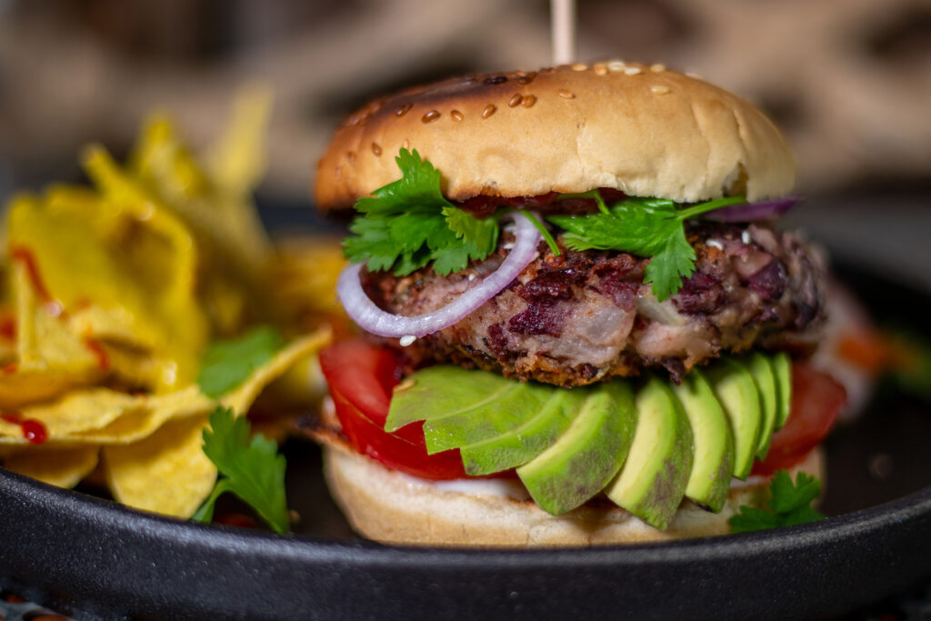 Veganer Bean Burger mit Tortilla Chips mit Keesesauce als Beilage