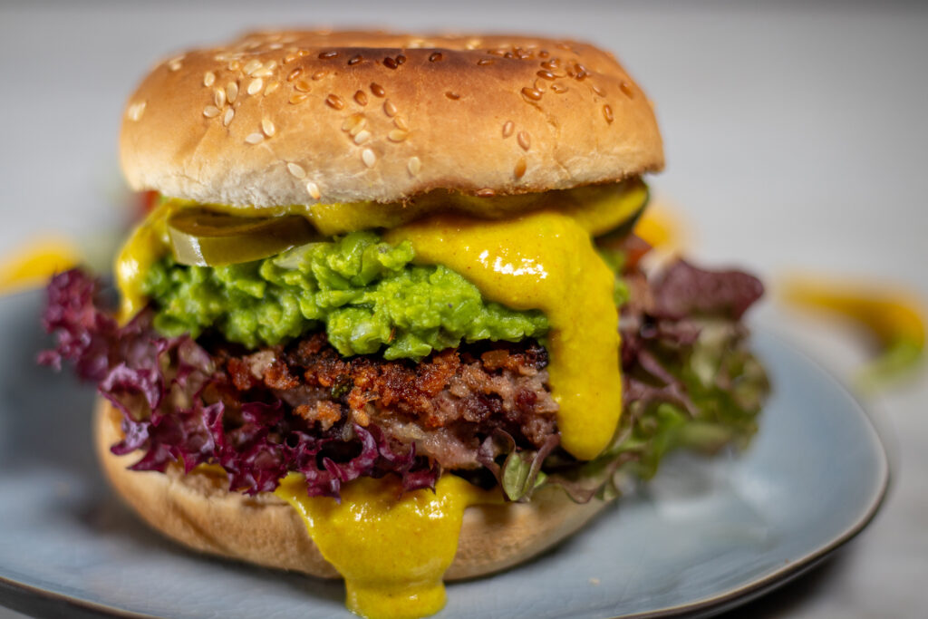 Erbsguacamole und Vegane Käsesauce auf Tex Mex Bean Burger