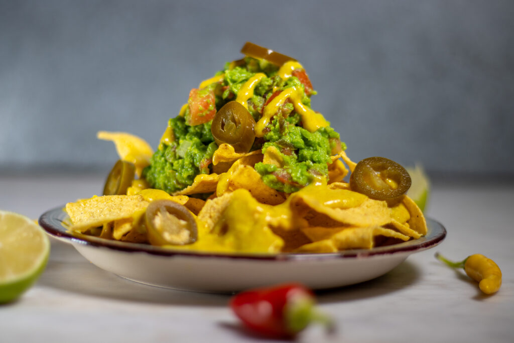 Loaded Nachos mit Erbsguacamole und veganer Käsesauce