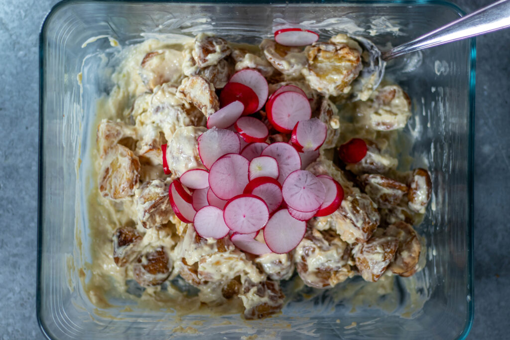 4. Die Röstkartoffeln für den Salat mit dem Myaodressing verrühren, dann noch die Radieschen unterheben.