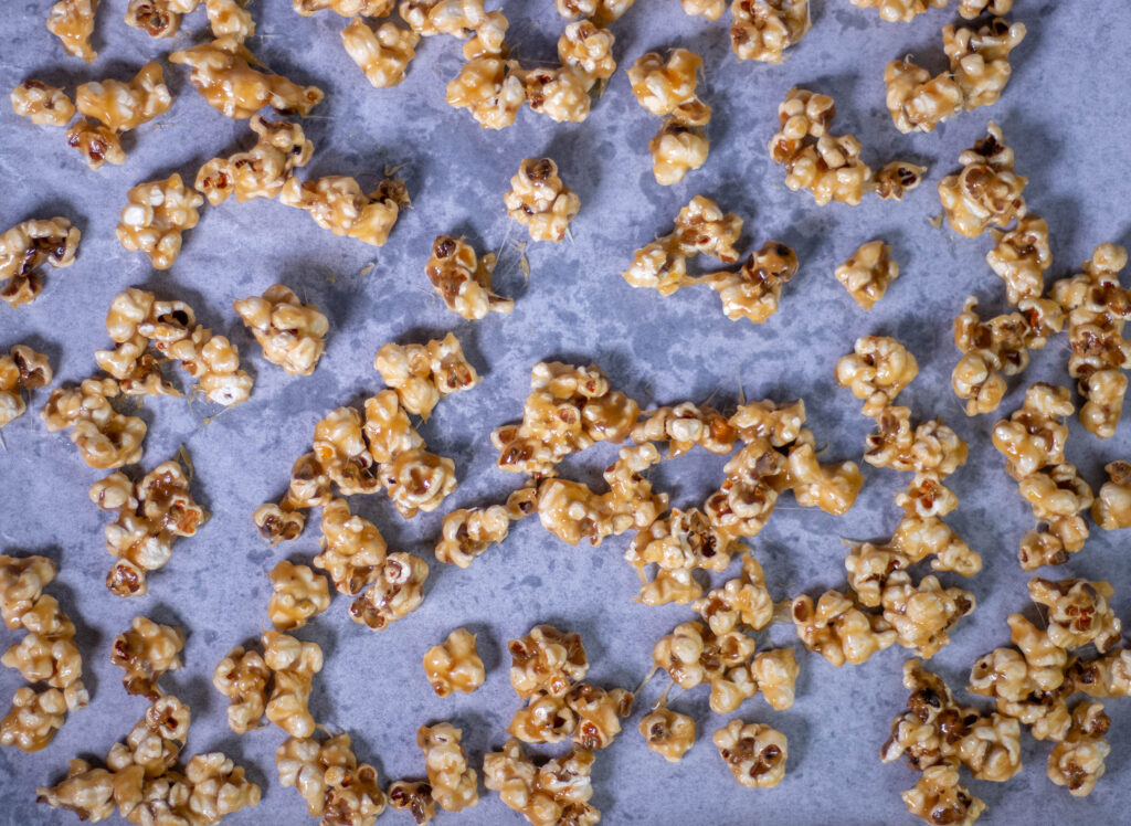 4. Das Popcorn auf Backblechen mit Backpapier verteilen und das Salzkaramell im Ofen knusprig backen.