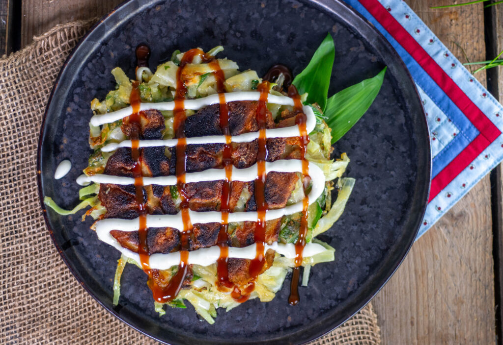 10. Die Okonomisauce und die vegane, japanische Mayonnaise auf den Bärlauch-Okonomiyaki geben.