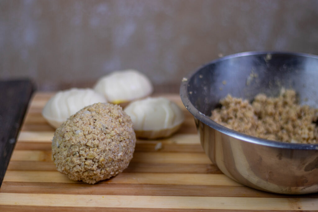 6. The egg halves are pressed together and I form a casing out of sausage meat.