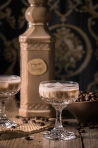 Baileys, homemade and vegan cream liqueur - in a bottle and in liqueur glasses on a wooden table