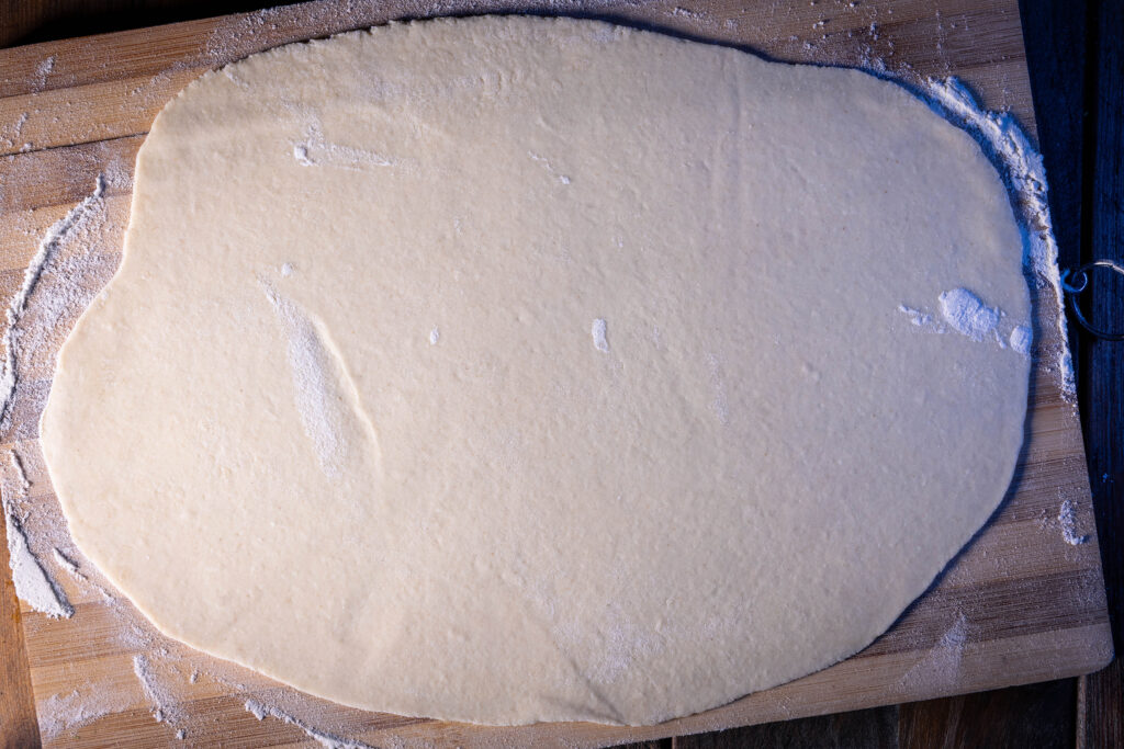 Ein ausgerollter Flammkuchenteig.