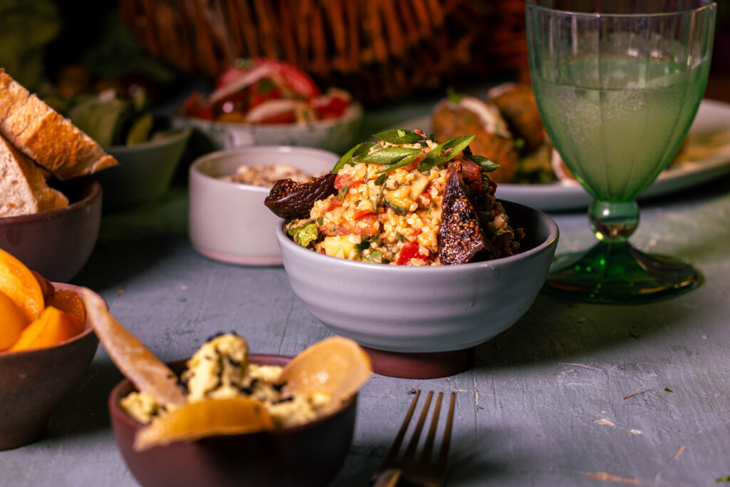 Bulgursalat mit Kefir-Joghurt-Dressing und verschiedene Mezze auf einem Tisch.