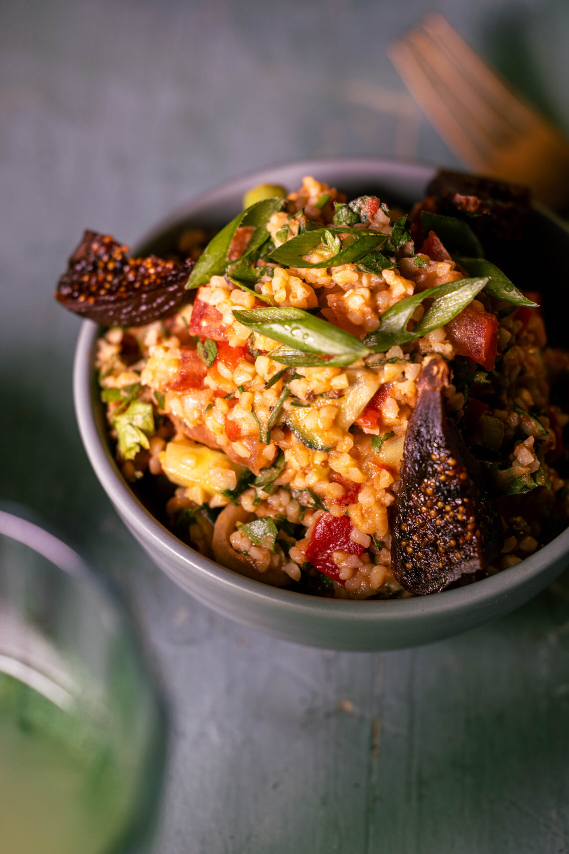 Bulgursalat mit Kefir und getrockneten Feigen in einer grünen Schale