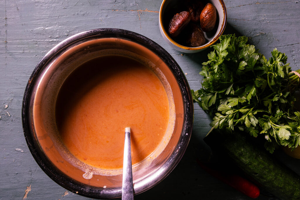 Eine Schale mit einem Dressing aus Wasserkefir, veganem Joghurt, Ayvar, Zitronensaft und Tomatenmark.