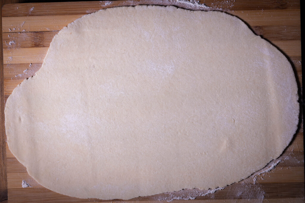 Flammkuchenteig hauchdünn ausrollen.