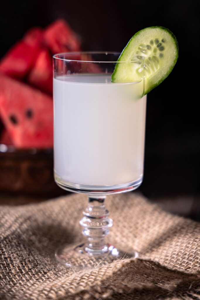 Wasserkefir in einem Glas mit einer Gurkenscheibe.
