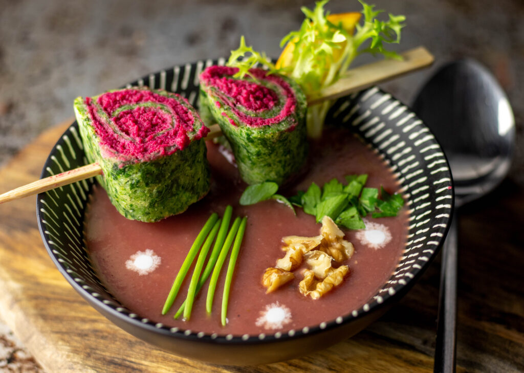 Hummus ist sehr gesund - hier als Beetehummus-Spinat-Spiralen auf Suppe.
