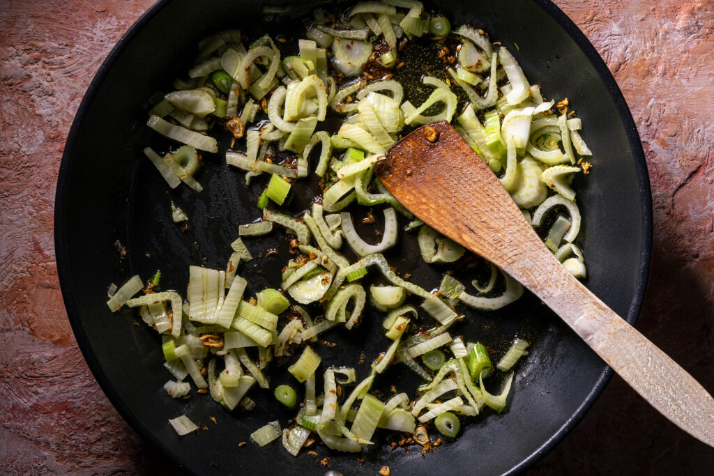 Fenchel und Gewürze braten in einer Pfanne.