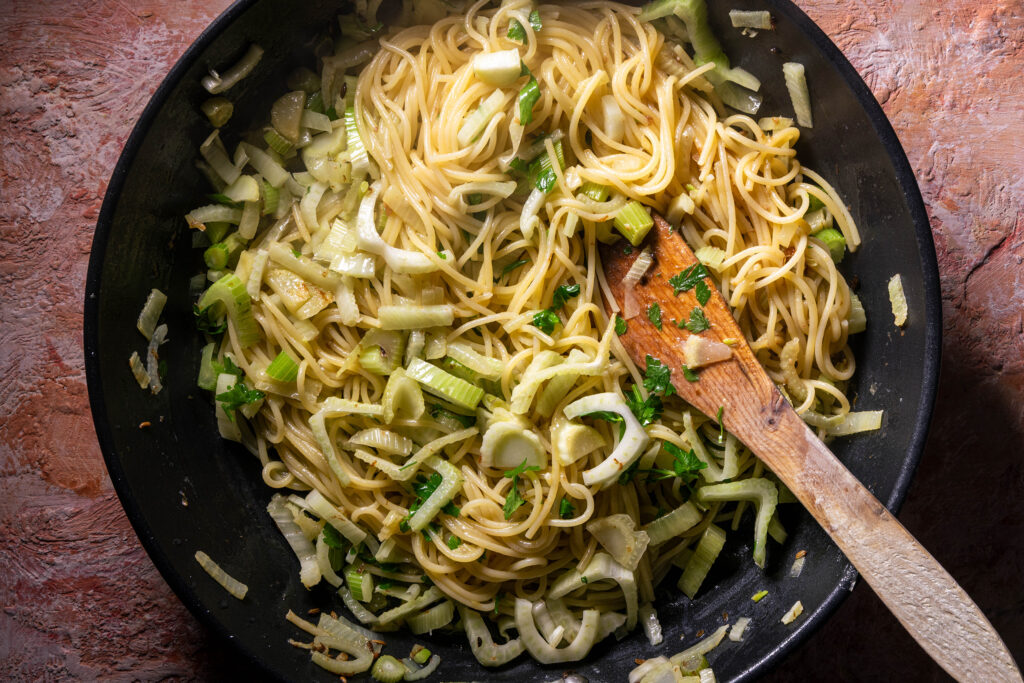 Pasta und Fenchel braten in einer Pfanne.